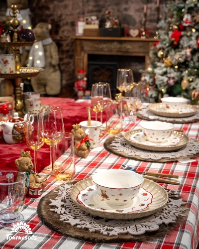 Table de Noël décorée dans un style champêtre avec sapin et cheminée.